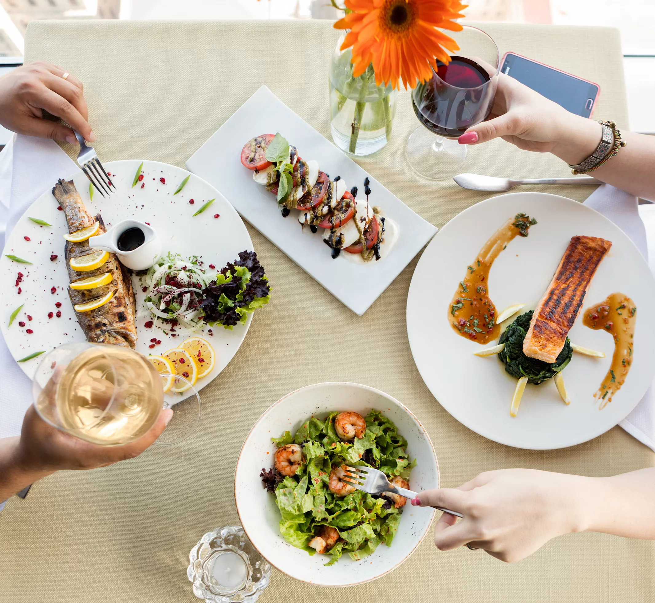 сouple_eating_fish_meal_with_lemon_and_white_wine