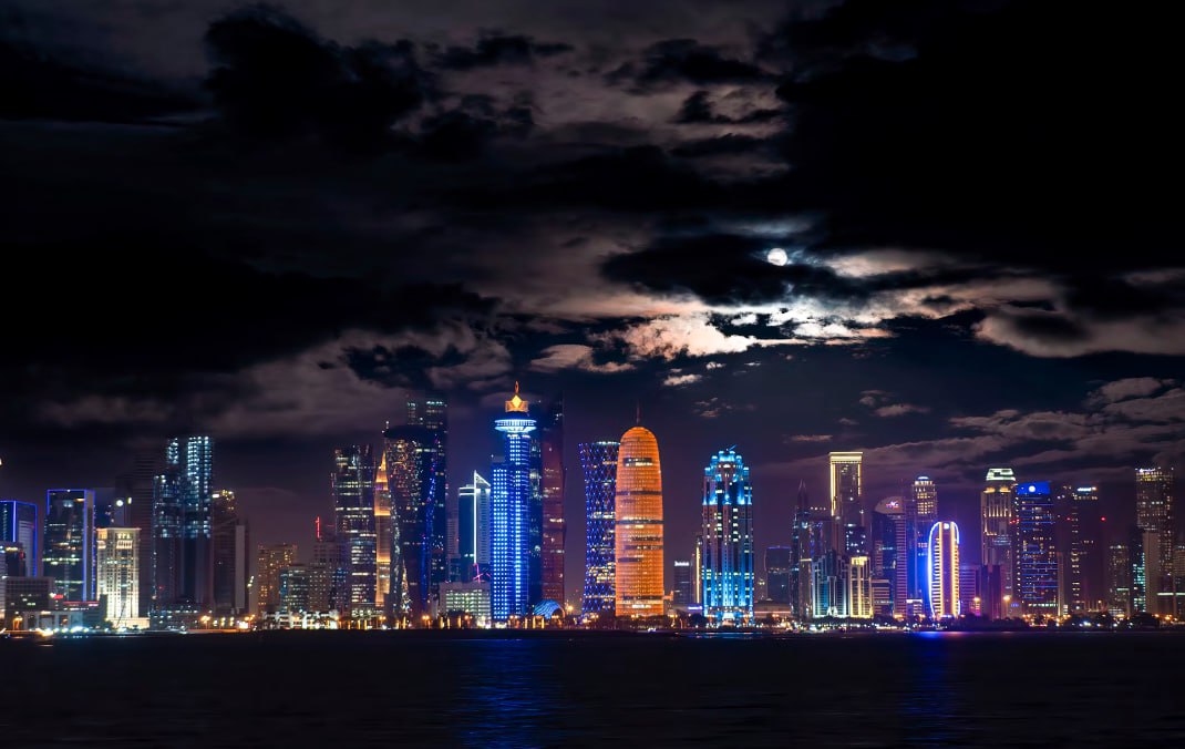 A City Skyline With A Full Moon In The Sky