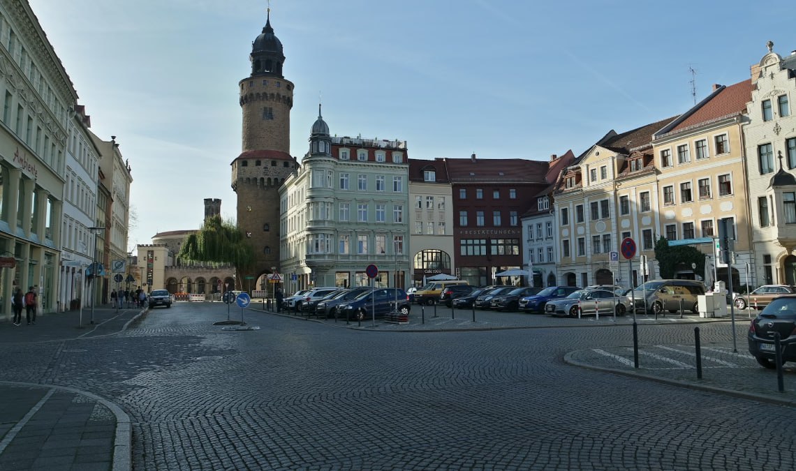 A City Street With A Clock Tower In The Background
