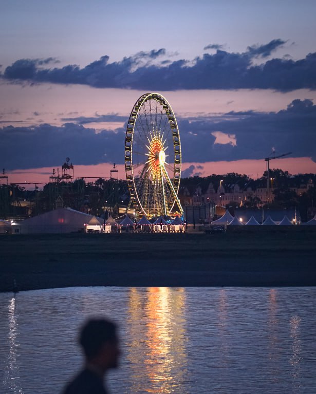 A Ferris Wheel Is Lit Up In The Night Sky