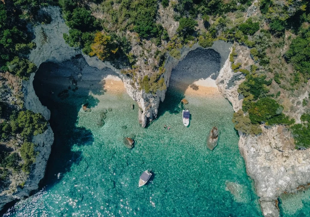 A Group Of Boats Floating On Top Of A Body Of Water