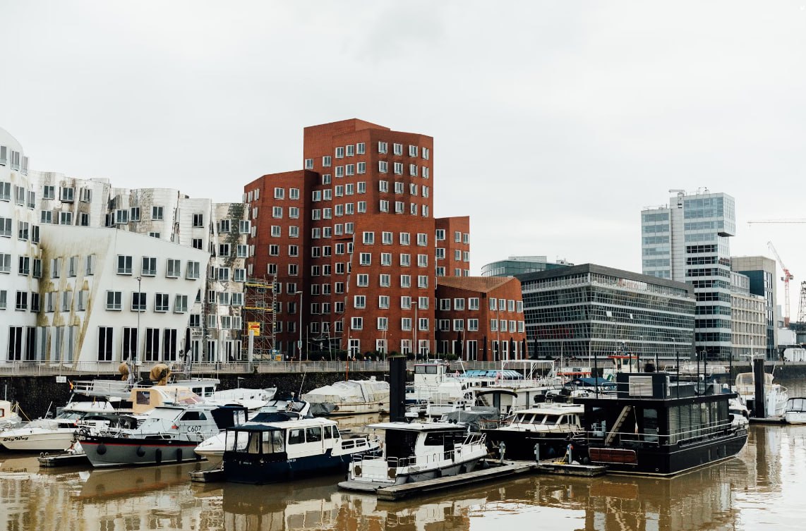 A Harbor Filled With Lots Of Boats Next To Tall Buildings