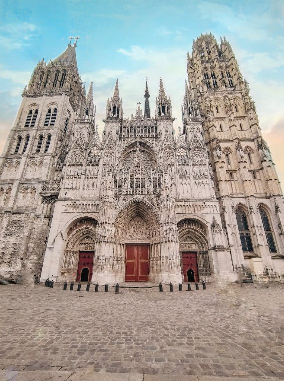 A Large Cathedral With A Red Door And Two Towers