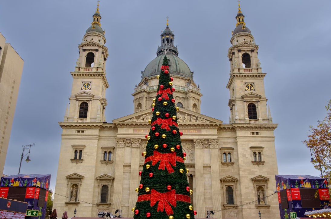 A Large Christmas Tree In Front Of A Church
