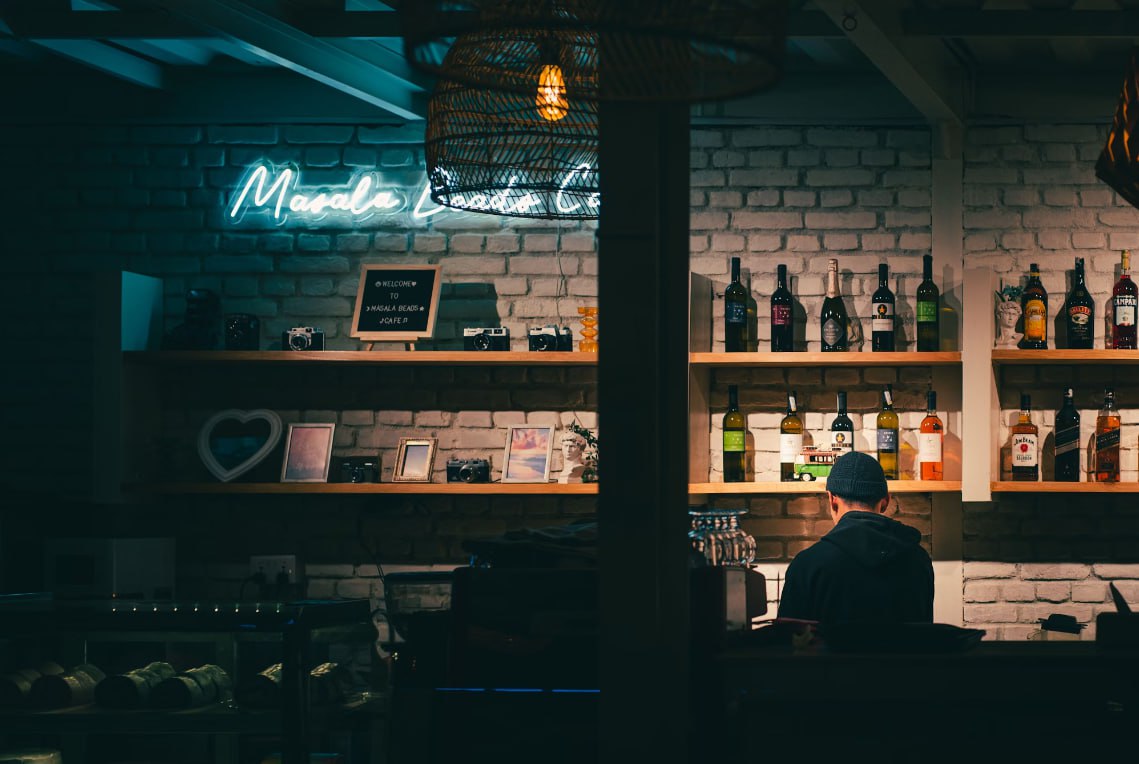A Man Sitting At A Bar In Front Of A Brick Wall