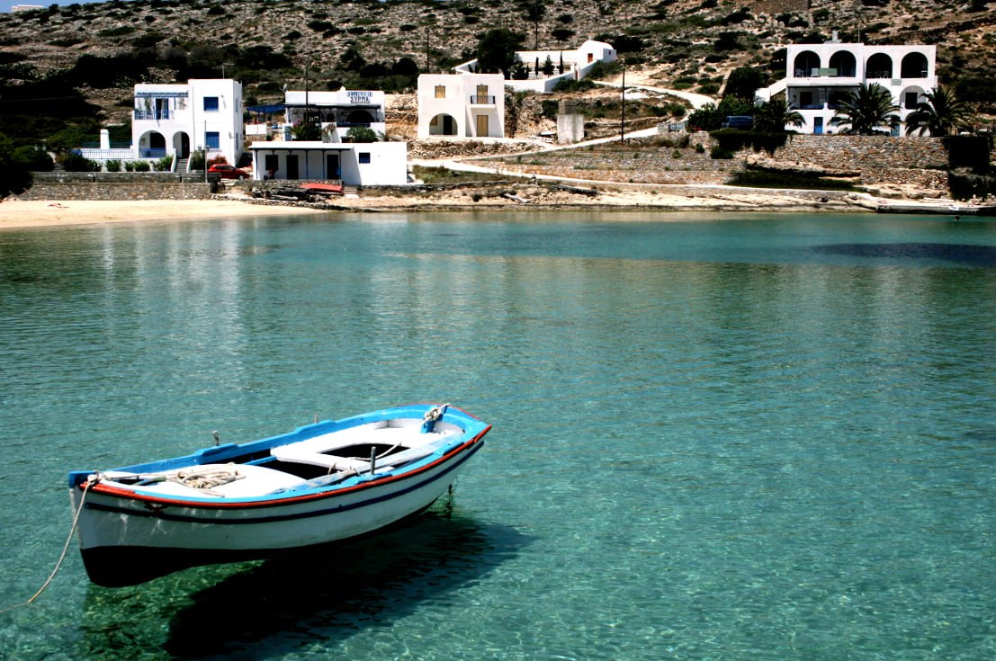A Small Boat Floating On Top Of A Body Of Water