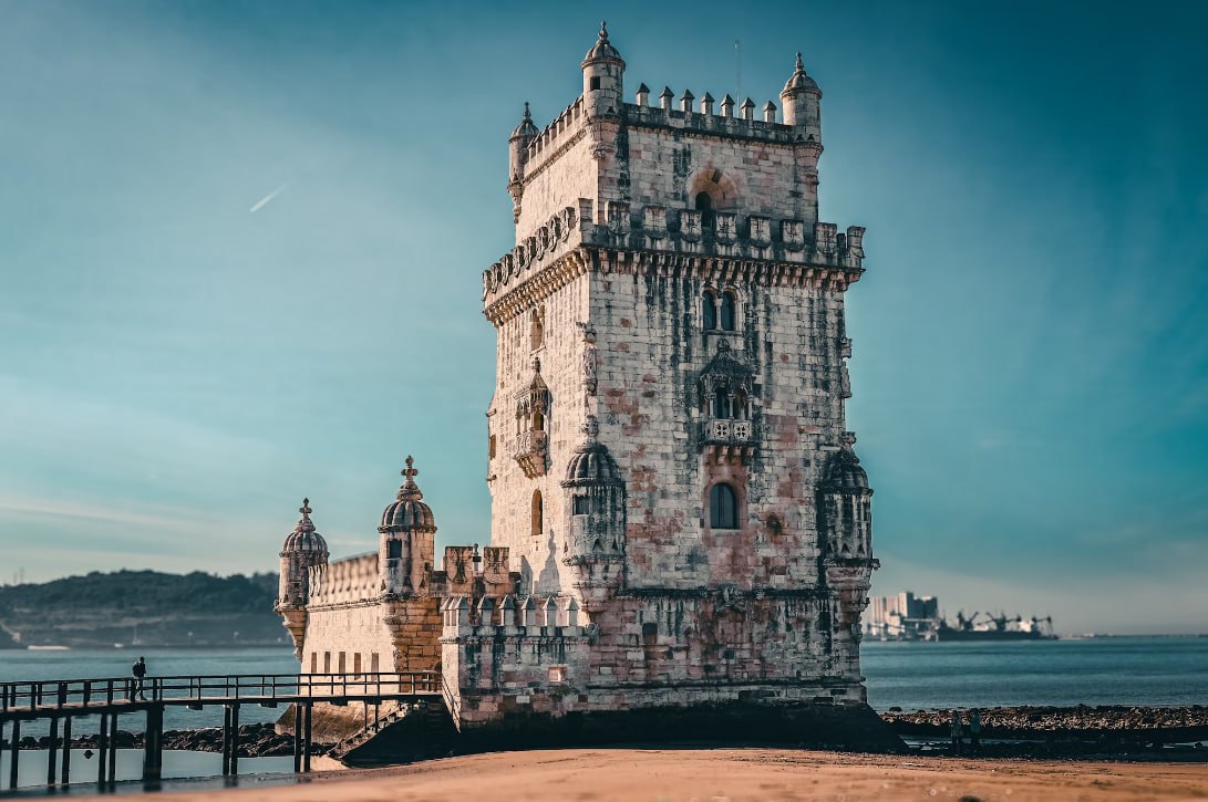 A Tall Tower Sitting Next To A Body Of Water