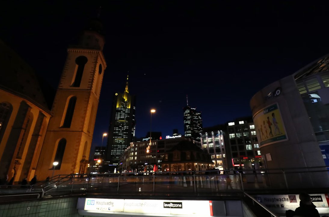 A View Of A City At Night From An Escalator