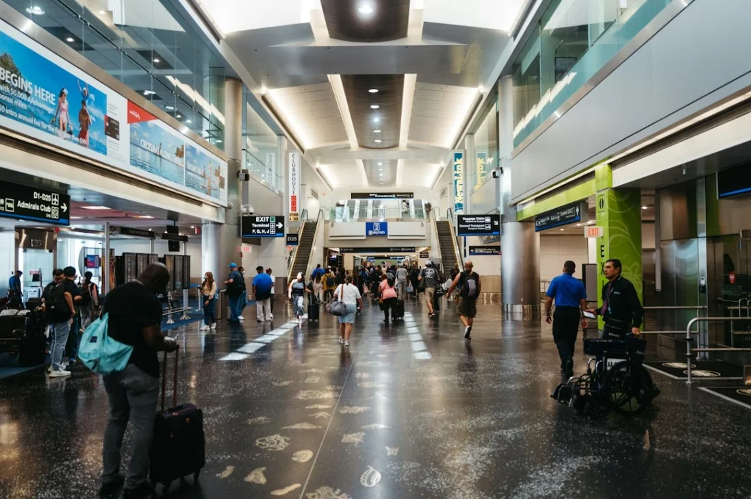 Pasajeros esperando cerca de las puertas de embarque en una terminal de aeropuerto concurrida