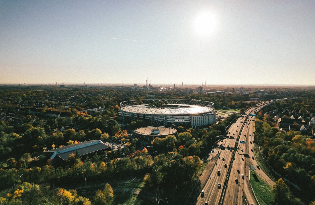 An Aerial View Of A Large Stadium Surrounded By Trees