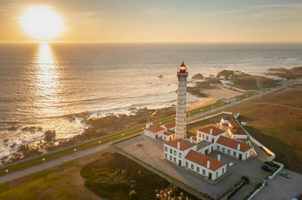 an-aerial-view-of-a-lighthouse-with-the-sun-in-the-background