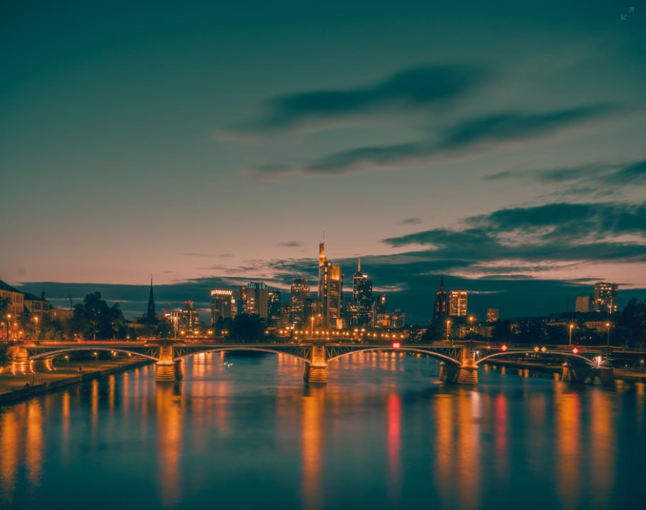 Body Of Water Near City Buildings During Night Time