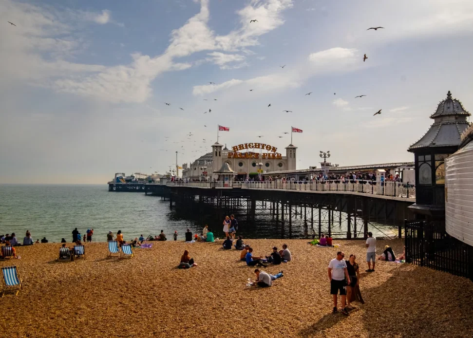 Muelle de Brighton y paseo marítimo con gente caminando por la playa