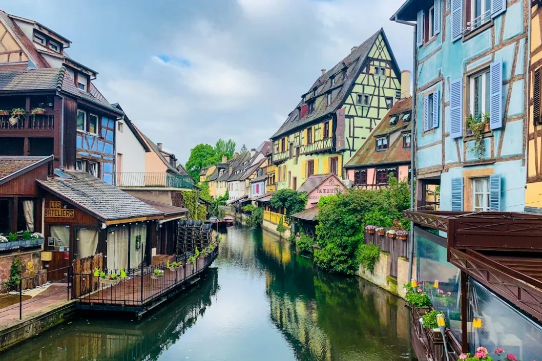 olmar-brown-and-white-concrete-buildings-beside-river-under-white-clouds-during-daytime