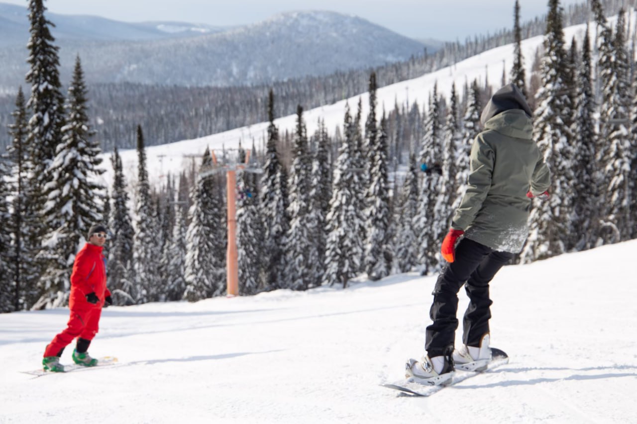 man_riding_a_snowboard_down_a_snow_covered_slope