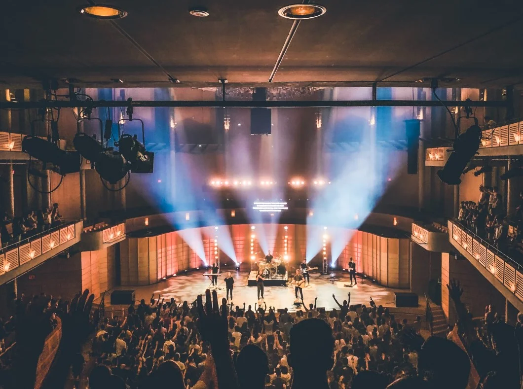 People Standing On Stage With Lights Turned On During