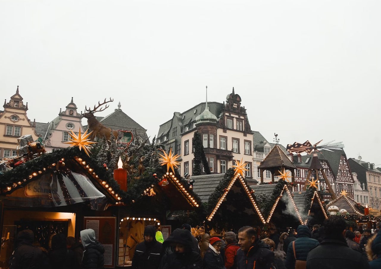 people_passing_by_black_and_brown_wooden_structures