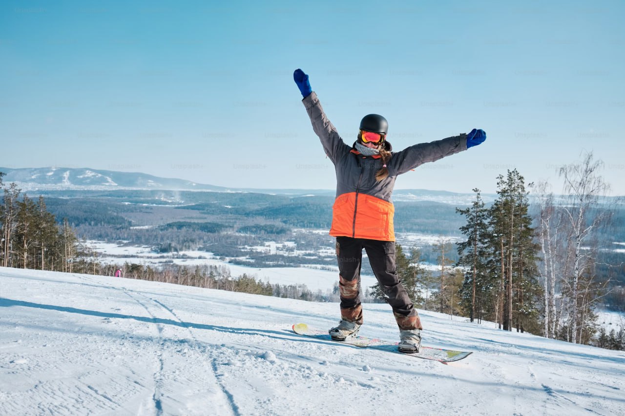 person_riding_a_snowboard_on_top_of_a_snow_covered_slope