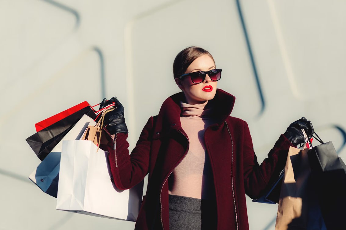 Photo Of Woman Holding White And Black Paper Bags