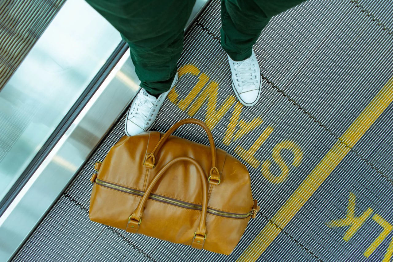 standing_on_a_moving_walkway_in_an_airport_with_luggage