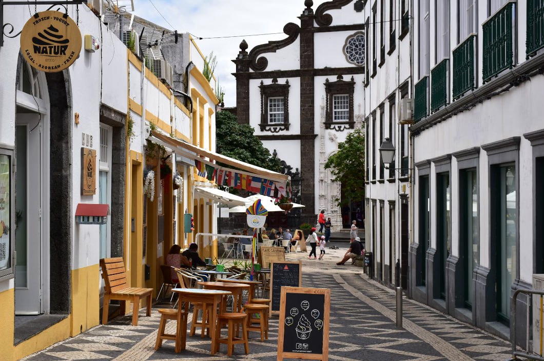 Street Lined With Buildings And Outdoor Cafes