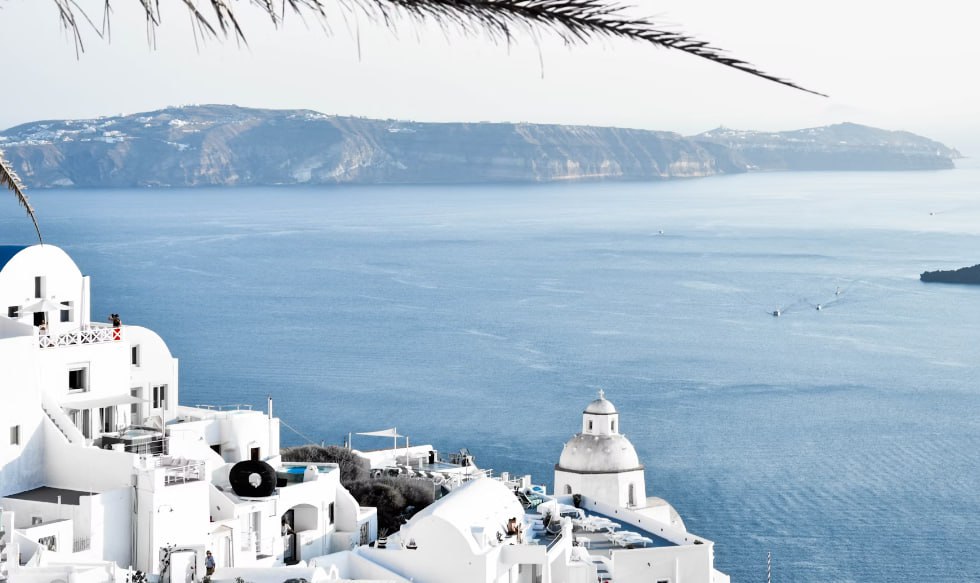White Concrete Buildings Near Ocean During Daytime