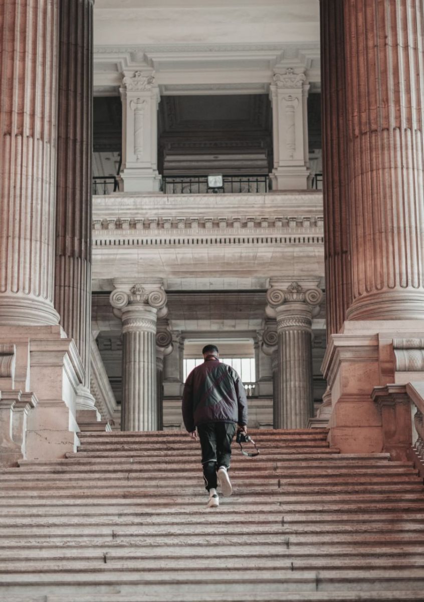 woman_in_black_jacket_walking_on_brown_concrete_stairs